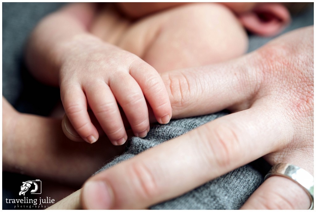 newborn hand holding parent's finger