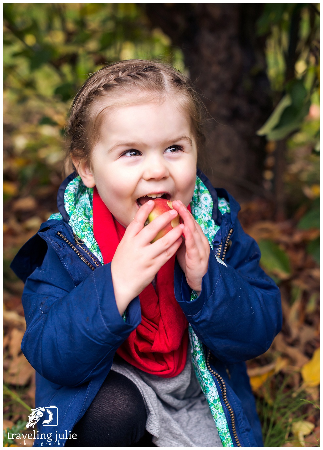 little girl happily eating an apple
